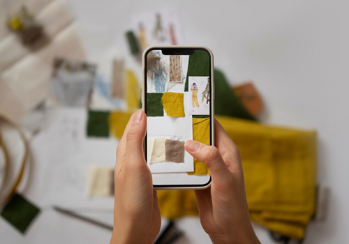 exemplo de mão segurando o celular e fotografando desenhos na parede